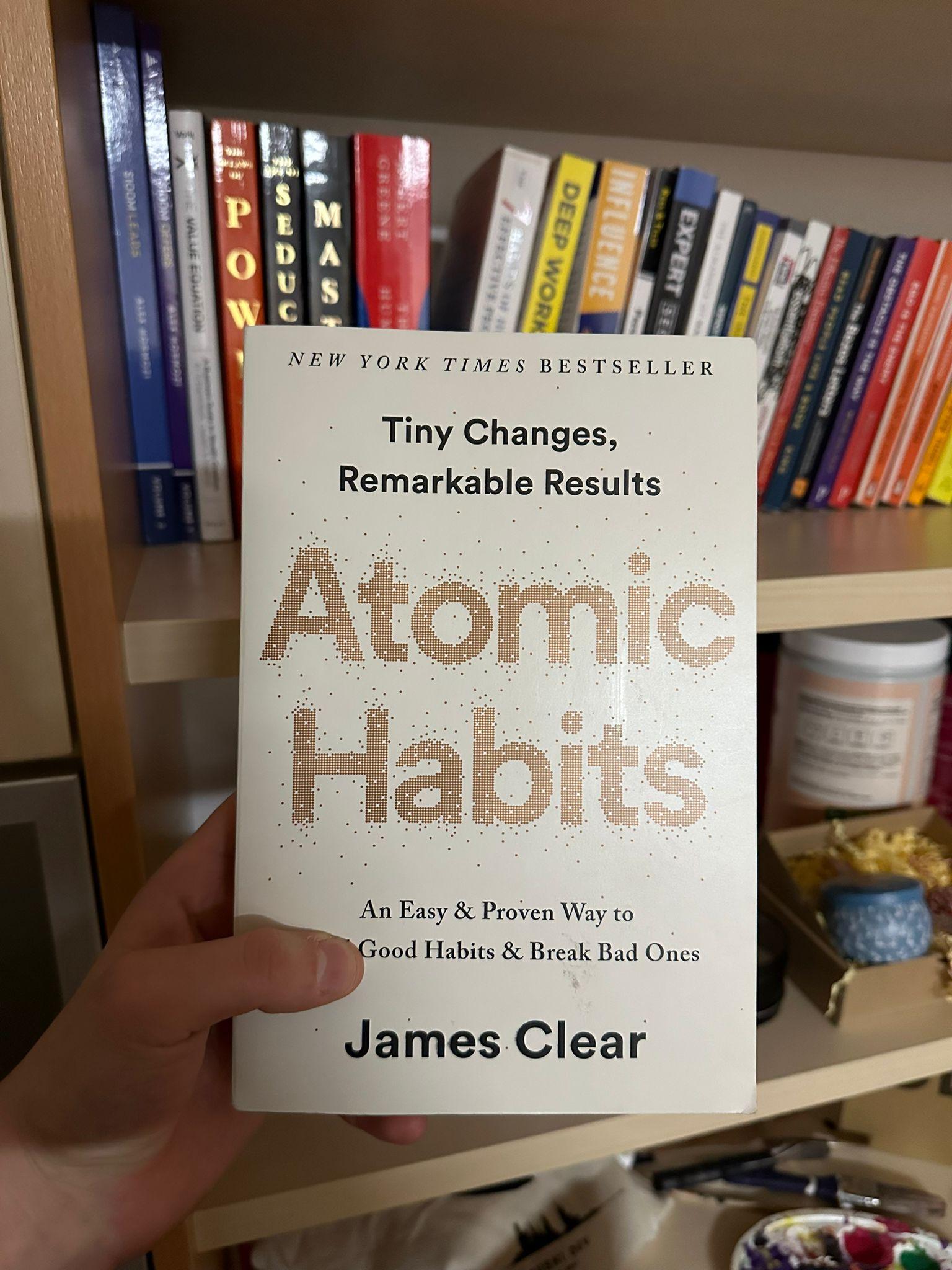 the acutal atomic habits book in my hand, beside other books